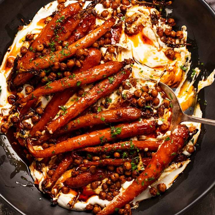 Spicy maple roasted carrots with crispy chickpeas with yogurt sauce on a plate